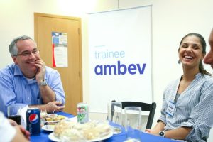 Duas pessoas conversam e riem na mesa enquanto lancham